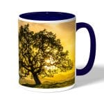 كوب قهوة بمقبض ازرق داكن بتصميم شجره الغروب