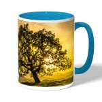 كوب قهوة بمقبض ازرق فاتح بتصميم شجره الغروب