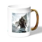 كوب قهوة بمقبض ذهبي بتصميم أساسنز كريد الثورة الأمريكية